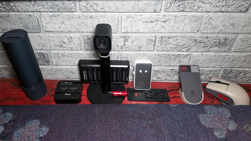 Several of my favorite under $50 gadgets, including a screwdriver in its case, M.2 cloner, webcam, travel adapter, and retro mouse